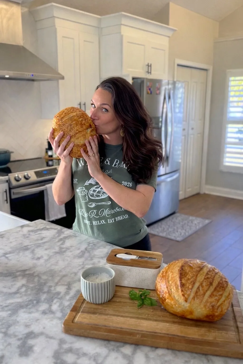 Lynsey holding a sourdough loaf in her home kitchen