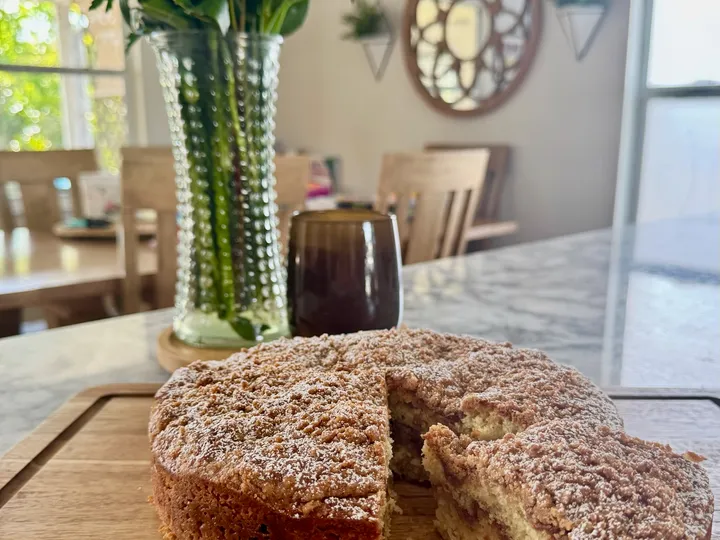 Sourdough coffee cake with crumb topping and flowers in the background